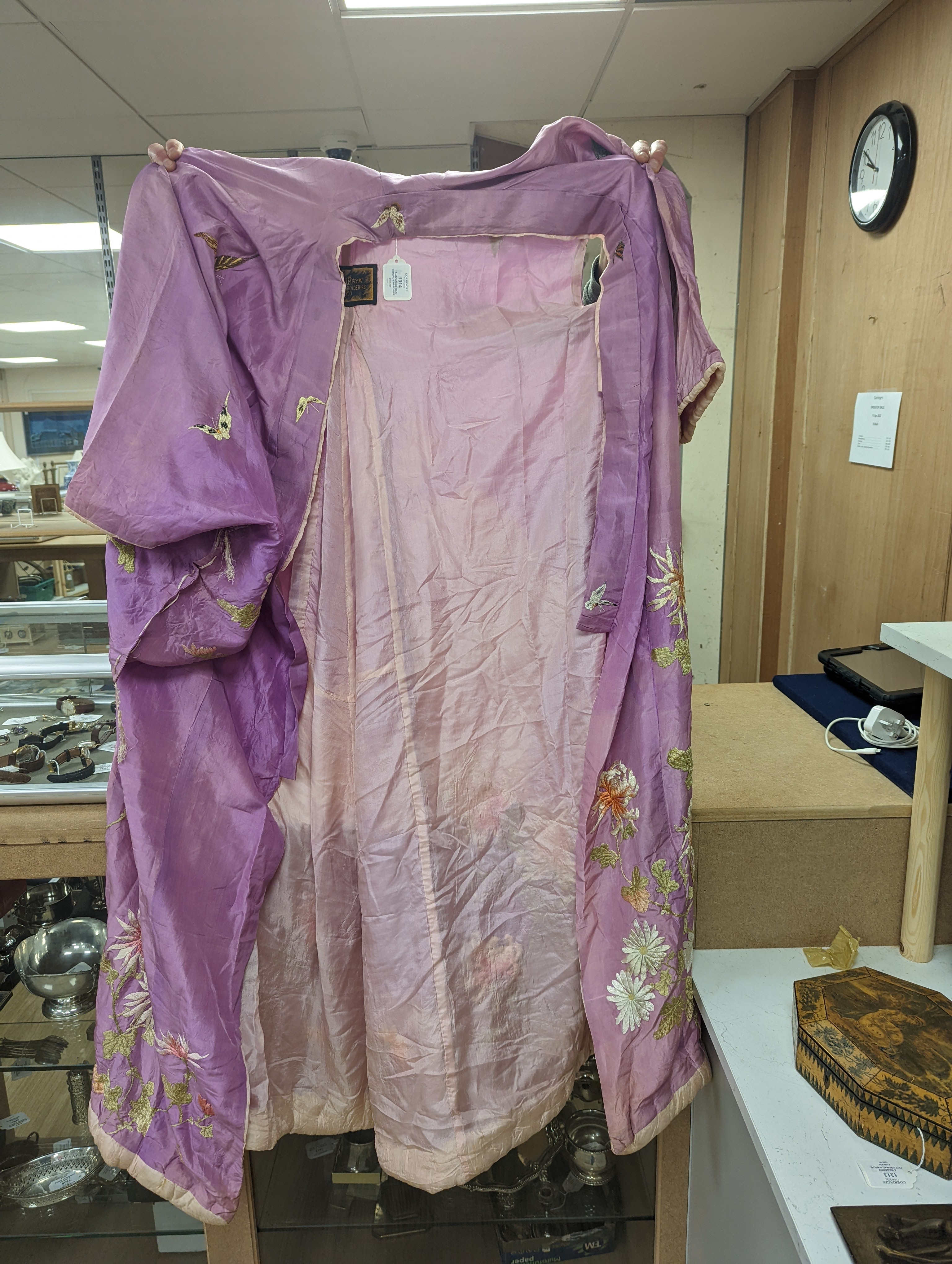 A Japanese silk kimono embroidered on mauve silk with multi-coloured butterflies and flowers, together with a cream silk unmade up kimono richly embroidered with a dragon design